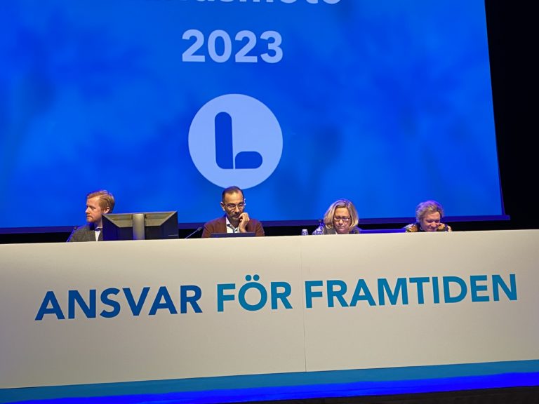 Bild på landsmötespresidiet på scenen. Fyra personer bakom ett långt bord.